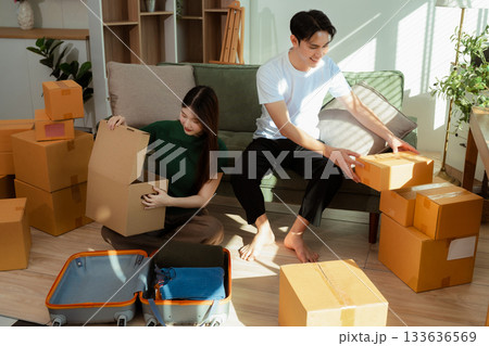 young couple helps put things in boxes and prepares to move to a new house. young couple helps put things in boxes and prepares to move to a new house. 133636569
