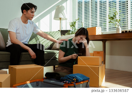young couple helps put things in boxes and prepares to move to a new house. young couple helps put things in boxes and prepares to move to a new house. 133636587