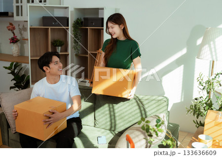 young couple helps put things in boxes and prepares to move to a new house. 133636609