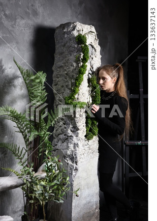 Minimalist black attire accentuated by nature and stone architecture 133637143