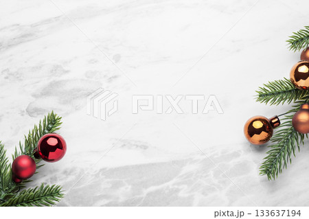Festive christmas decoration, pine branches with christmas balls on marble table background, top view Festive christmas decoration, pine branches with christmas balls on marble table background, top view 133637194