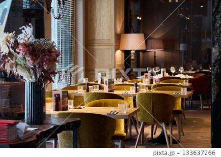 sunny cafe with elegant decor, luminous restaurant featuring plush seats and charming accents 133637266