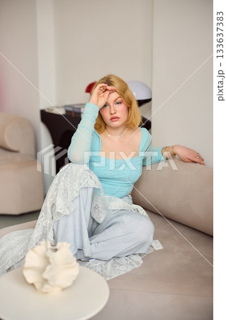 exhausted artist repose, tired blonde woman gently recovering in serene and comforting living space 133637383