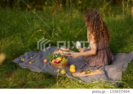 Peaceful scene depicting woman resting on blanket amid nature and sunlight Peaceful scene depicting woman resting on blanket amid nature and sunlight 133637404