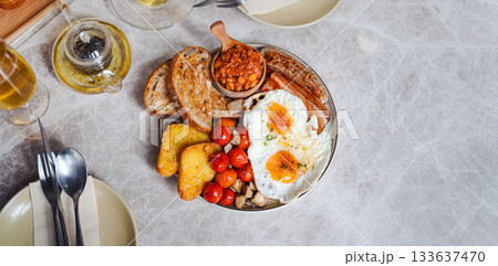 English breakfast menu fried eggs in grilled tomato and bacon sausage plate traditional tasty meal 133637470