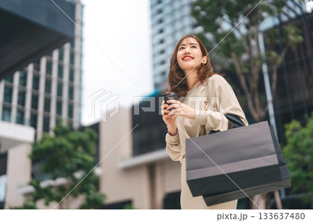 Single adult asian business woman holding take away coffee cup and shopping bag Single adult asian business woman holding take away coffee cup and shopping bag 133637480