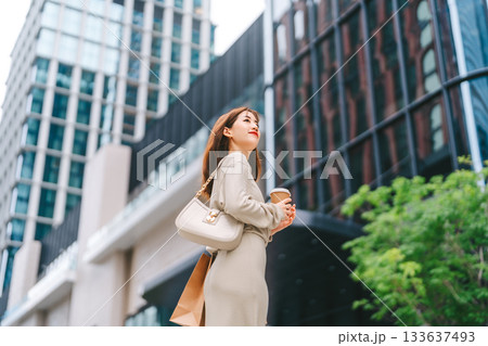 Single adult business asian woman holding coffee cup and shopping bag on black friday sale city people lifestyle 133637493