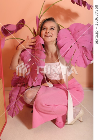 Serene woman relaxing amidst pastel greenery in casual fashion 133637569