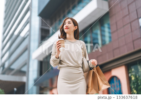 Single adult business asian woman holding coffee cup and shopping bag city people lifestyle 133637618