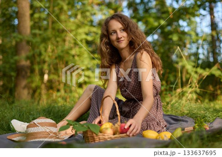 Woman appreciates serene picnic surrounded by natural beauty 133637695