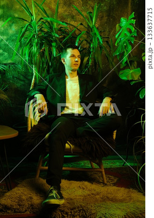 Stylish man in sharp clothing amid tropical outdoor setting Stylish man in sharp clothing amid tropical outdoor setting 133637715
