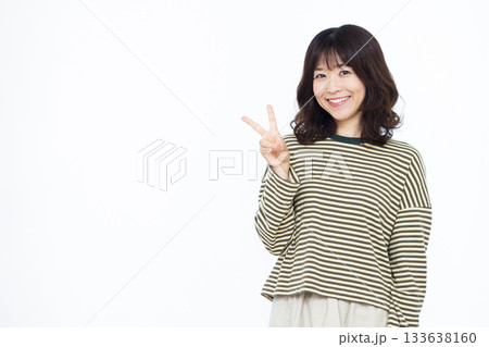 笑顔でピースサインをしている女性 笑顔でピースサインをしている女性 133638160