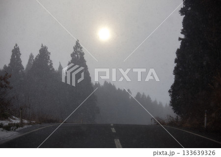 冬の太陽と雪降る国道 133639326
