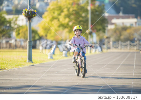 日本の公園でピンクの自転車に乗る女児のアクティブなサイクリング 133639517