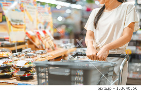 Young adult asian woman consumer choosing ready meals cooked food at supermarket store choice buying Young adult asian woman consumer choosing ready meals cooked food at supermarket store choice buying 133640350