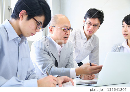 会社で企画会議をする若い社員と部長 会社で企画会議をする若い社員と部長 133641205
