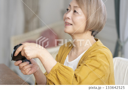 リビングでテレビゲームを楽しむシニア女性 133642525