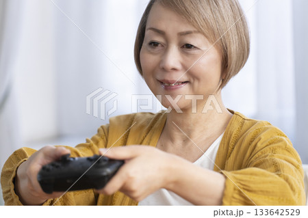 リビングでテレビゲームを楽しむシニア女性 133642529