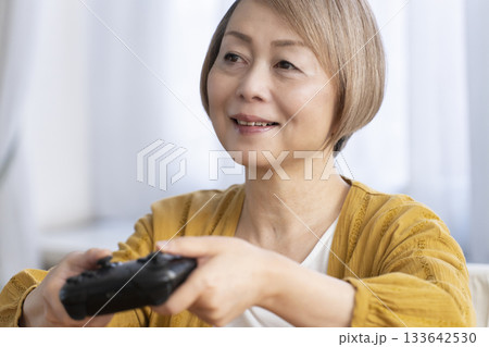リビングでテレビゲームを楽しむシニア女性 133642530