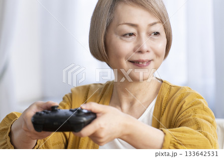 リビングでテレビゲームを楽しむシニア女性 133642531