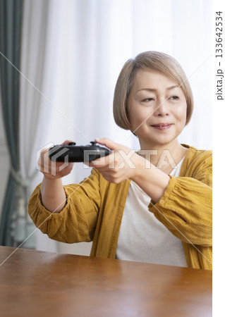 リビングでテレビゲームを楽しむシニア女性 133642534