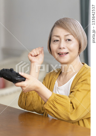 リビングでテレビゲームを楽しむシニア女性 133642537