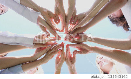 An inspiring display of unity with a variety of diverse hands reaching together in a beautiful circular formation 133643162