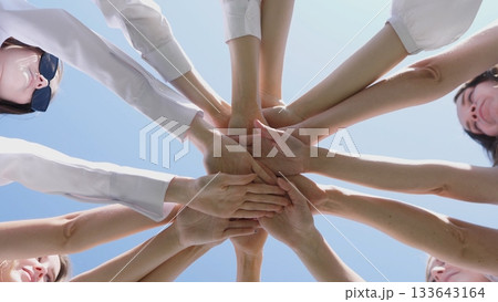 Hands coming together symbolizes unity, teamwork, and collaboration in a thriving, positive environment Hands coming together symbolizes unity, teamwork, and collaboration in a thriving, positive environment 133643164