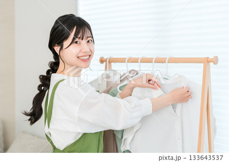 洋服をハンガーにかけてハンガーラックに吊るす家事をする主婦のアジア人女性 133643537
