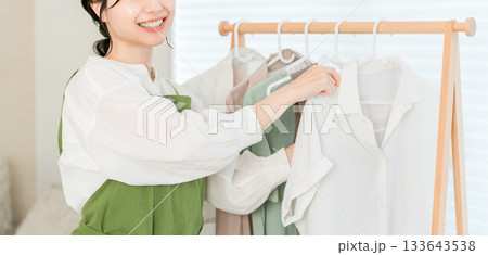 洋服をハンガーにかけてハンガーラックに吊るす家事をする主婦のアジア人女性 133643538