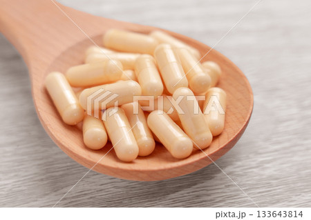 Full wooden spoon with supplement capsules containing amino acids close up Full wooden spoon with supplement capsules containing amino acids close up 133643814