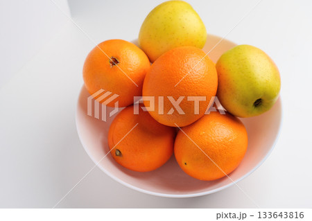 Fresh citrus fruits and green yellow seasonal apples in a white ceramic bowl Fresh citrus fruits and green yellow seasonal apples in a white ceramic bowl 133643816