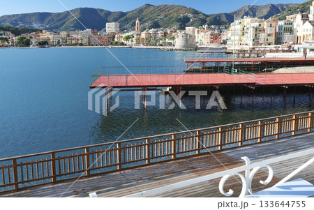 Panoramic view of traditional buildings and structures of Liguria. Mountains of Italy. Mediterranean nature, Europe. Sky, sea, and palm trees of Rapallo. Design backdrop. Tourism and recreation. 133644755