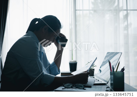 Stressed businesswoman working late at home office, feeling exhausted while reviewing financial documents on laptop. Concept of work stress, burnout, deadline and overwork. Stressed businesswoman working late at home office, feeling exhausted while reviewing financial documents on laptop. Concept of work stress, burnout, deadline and overwork. 133645751