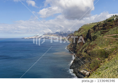 Madeira Atlantic coast near Garajau with steep green cliffs and distant white Funchal views 133646346
