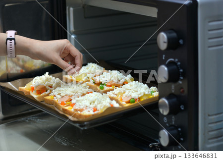 home cooking With slices of bread, topped with cheese, sausage, ham, beans and carrots, ready to bake in the electric oven. 133646831