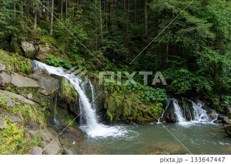 Mountain waterfall in the forest. Green nature. Mountain waterfall in the forest. Green nature. 133647447
