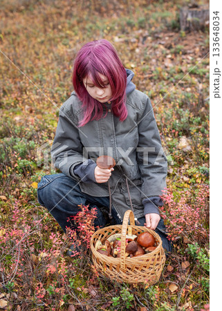 Girl foraging wild mushrooms in autumn forest 133648034