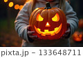 Child's Mummy Hands Holding Friendly Smiling Jack-o-Lantern Pumpkin 133648711