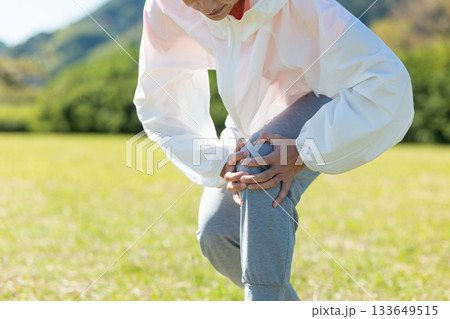 屋外で運動中に膝を痛めるミドル女性 133649515