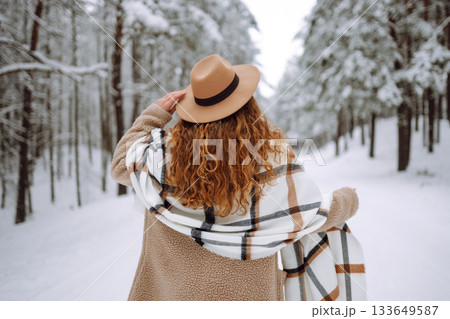 Beautiful woman posing with her back in the winter forest. Great winter weather and atmosphere. Beautiful woman posing with her back in the winter forest. Great winter weather and atmosphere. 133649587