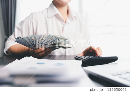 Business woman analyze calculate company financial, tax results office accounting statistics analytical research. calculating business balance prepare tax reduction. Tax deduction planning concept. Business woman analyze calculate company financial, tax results office accounting statistics analytical research. calculating business balance prepare tax reduction. Tax deduction planning concept. 133650061