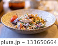 Fresh caesar salad with grilled chicken and cherry tomatoes in rustic ceramic bowl 133650664