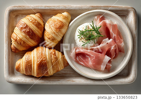 Instagram aesthetic. Top view. Tray with cornetti, prosciutto and fresh ricotta in plate on a white background. Italian spread. European hotel breakfast.  133650823