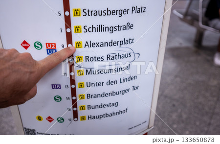 Berlin, Germany, August 10, 2023. On the subway, a hand points to the Alexanderplatz stop on the information board. Lifestyle using public transportation. Berlin, Germany, August 10, 2023. On the subway, a hand points to the Alexanderplatz stop on the information board. Lifestyle using public transportation. 133650878