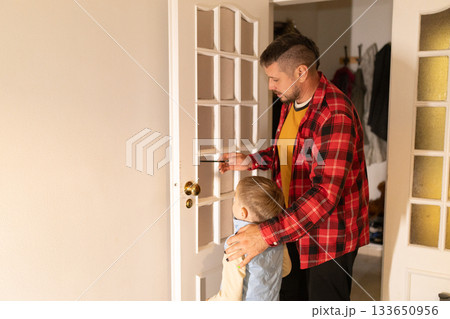 Father teaching son about safety entering returning home Father teaching son about safety entering returning home 133650956