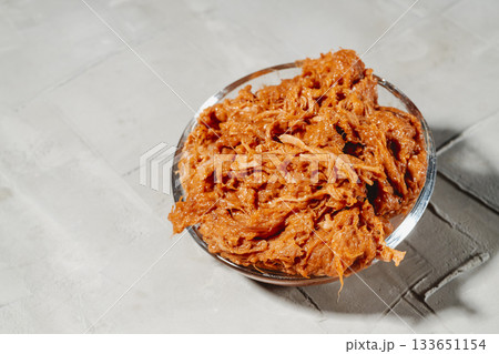 glass bowl packed with moist shredded pulled pork 133651154