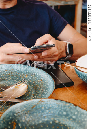 a man uses a phone connected to a power bank 133651157