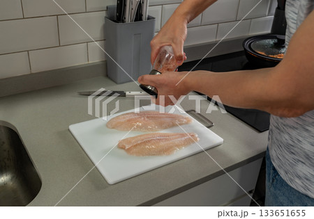 Middle aged man cooking fish fillet Middle aged man cooking fish fillet 133651655