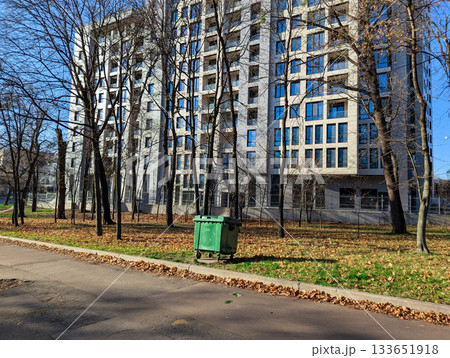 a residential complex and a trash bin in an autumn park a residential complex and a trash bin in an autumn park 133651918